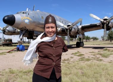 Jessica Cox in front of airplane in pilot gear